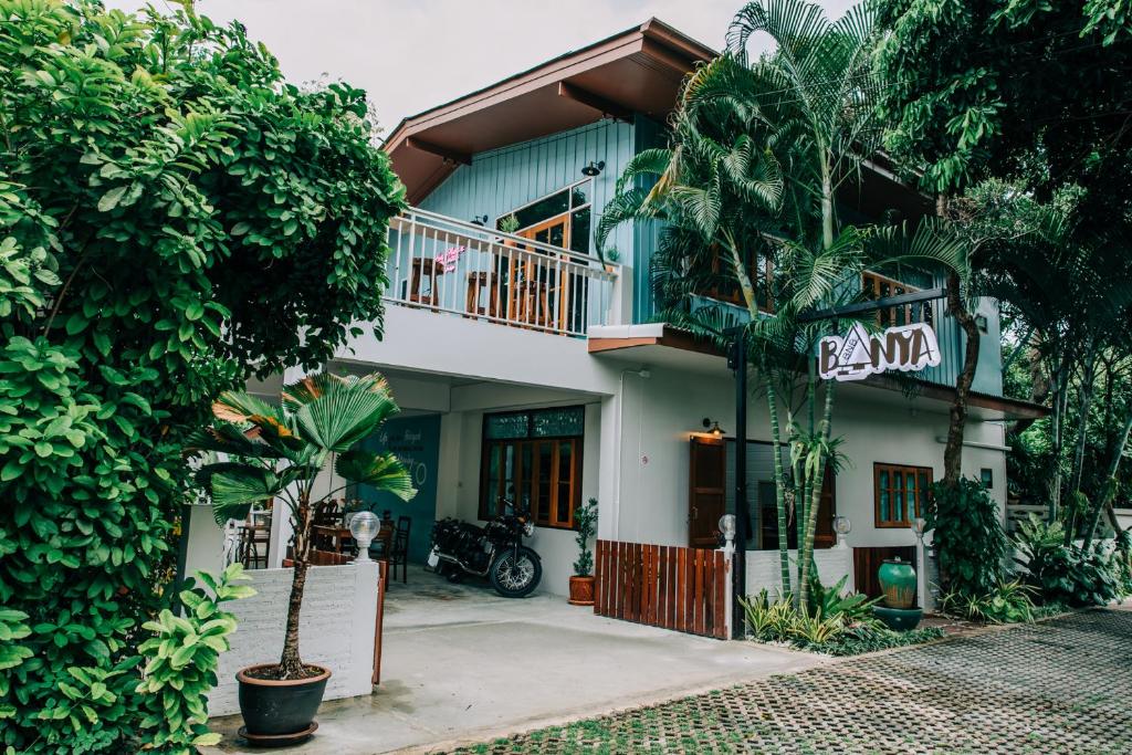 una casa con balcone e alberi di Banya BnB ที่พักบ้านย่าบีแอนด์บี เมืองประจวบฯ a Prachuap Khiri Khan