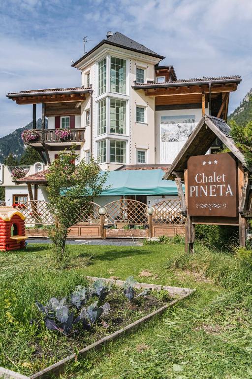 a house with a sign in front of it at Chalet Pineta relax location in Canazei