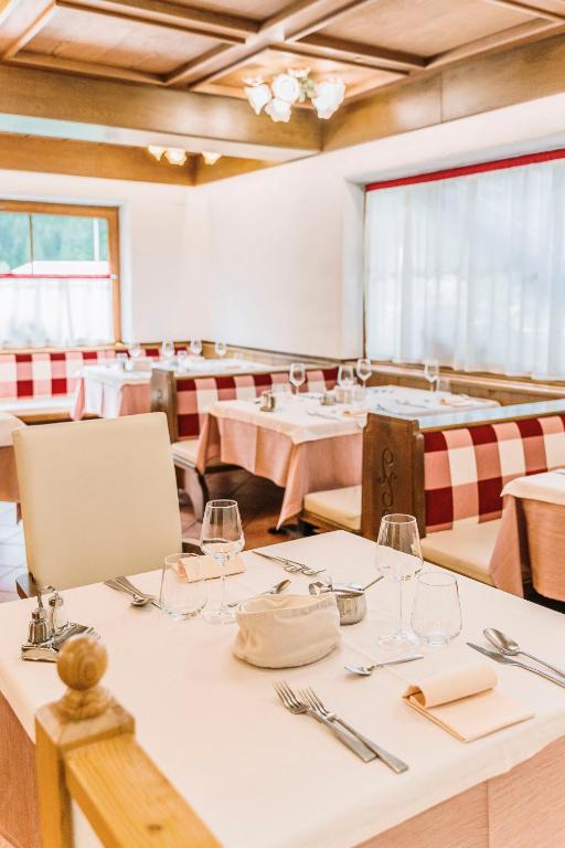 a dining room with tables and chairs with wine glasses at Chalet Pineta relax location in Canazei