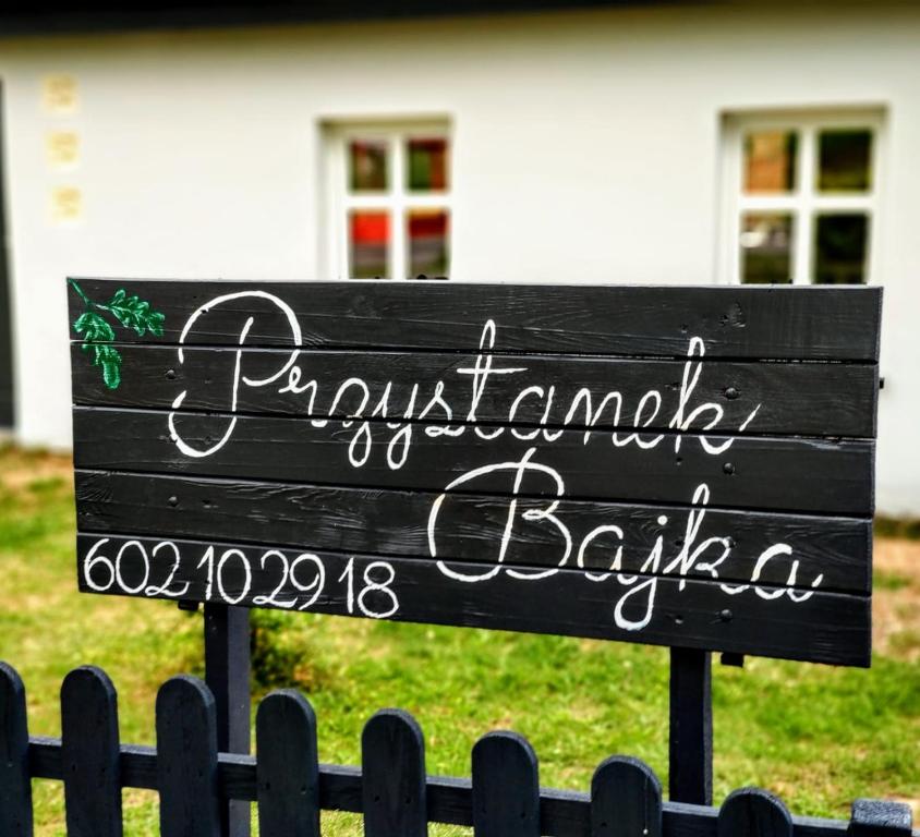 una señal frente a una casa en Przystanek Bajka w Puszczy Zielonce en Dąbrówka Kościelna