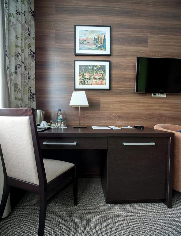 a desk with a chair and a television in a room at Business Hotel Diplomat in Nizhny Novgorod
