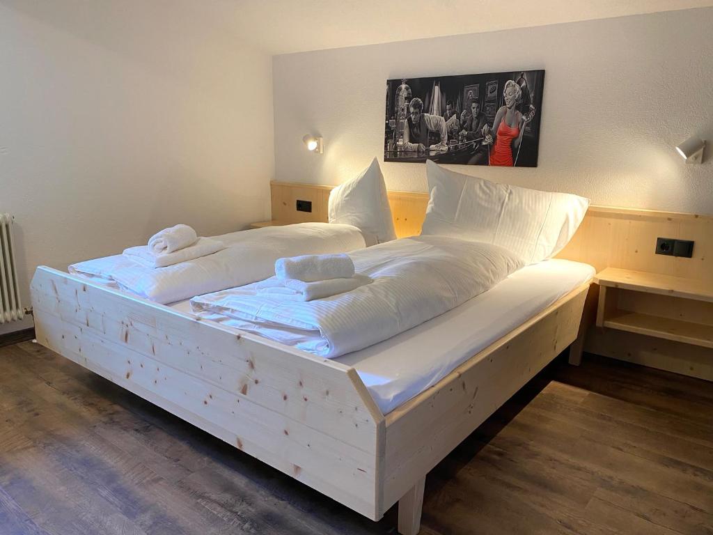 1 dormitorio con 2 camas con sábanas y almohadas blancas en Familien-Apartment mit Balkon und Bergblick, en Umhausen