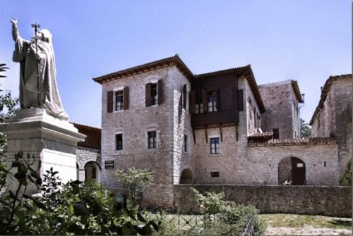a large stone building with a statue in front of it at Guesthouse Kazakou in Dimitsana