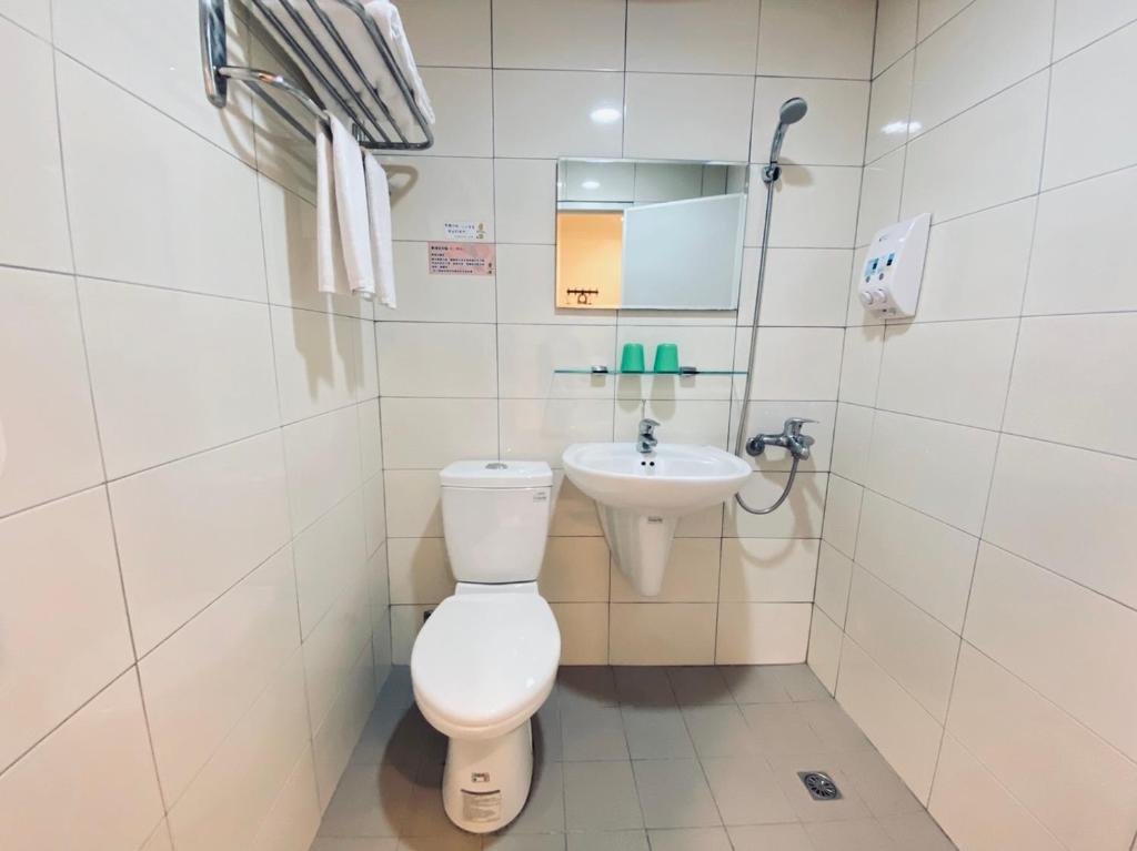 a bathroom with a toilet and a sink at Lai Chi Te Hotel in Tainan