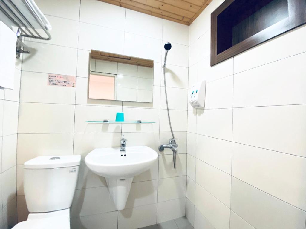 a bathroom with a toilet and a sink at Lai Chi Te Hotel in Tainan