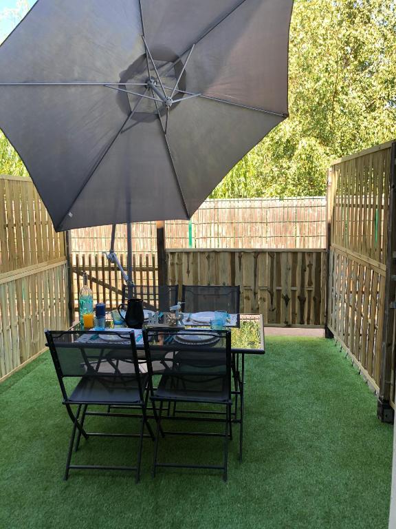 - une table et des chaises sous un parasol dans la cour dans l'établissement Studio Royan centre, à Royan