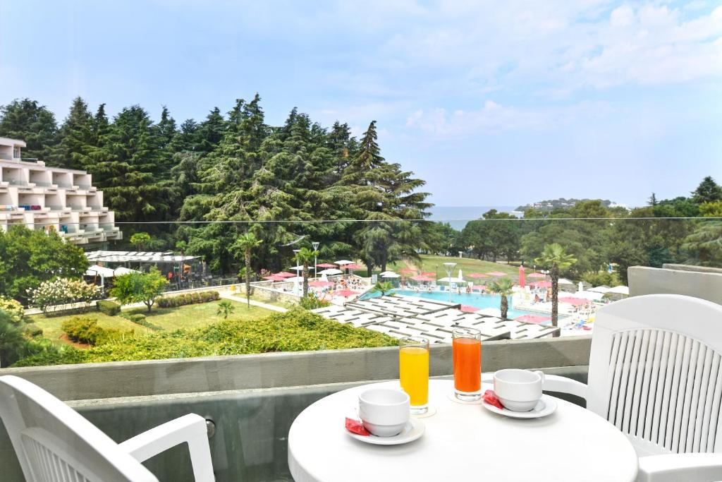 a table and chairs with a view of a pool at Hotel Mediteran Plava Laguna in Poreč