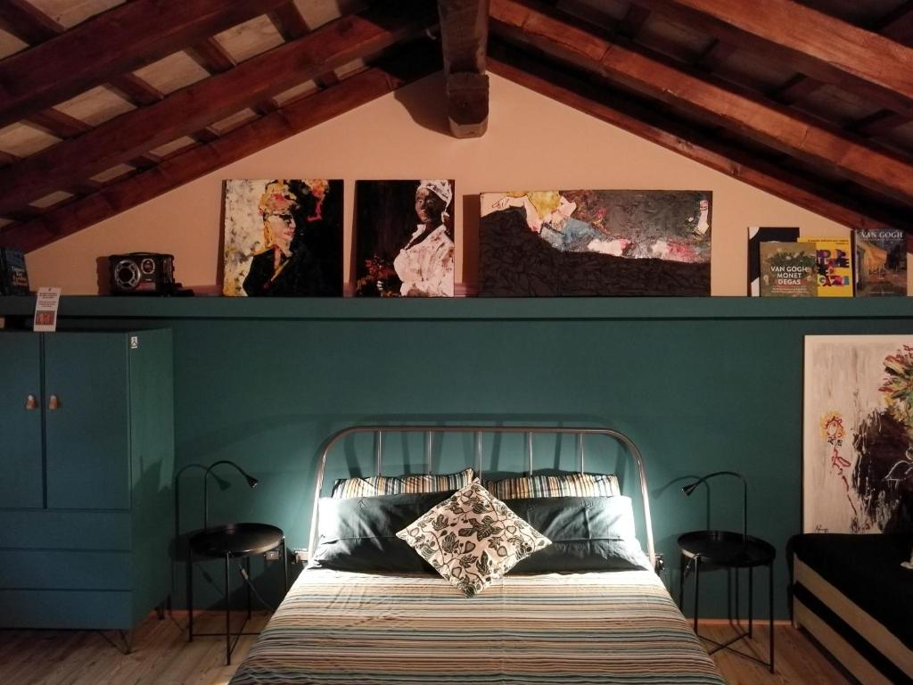 łóżko w pokoju ze zdjęciami na ścianie w obiekcie Relais San Rocco w mieście Mira