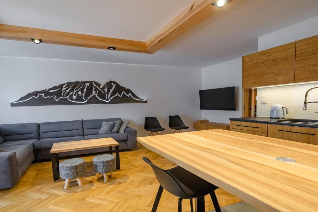 uma cozinha e sala de estar com uma grande mesa de madeira em Rent like home - Za Cieszynianką 3 em Zakopane