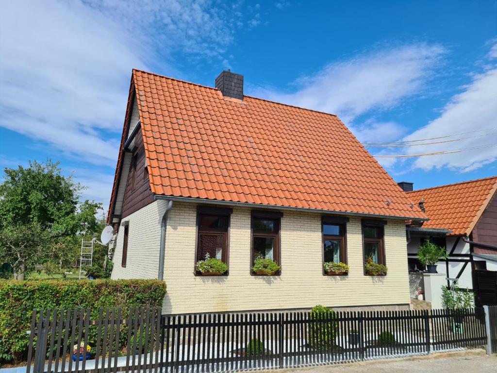 una casa blanca con techo naranja en Ferienhaus Heider, en Darlingerode