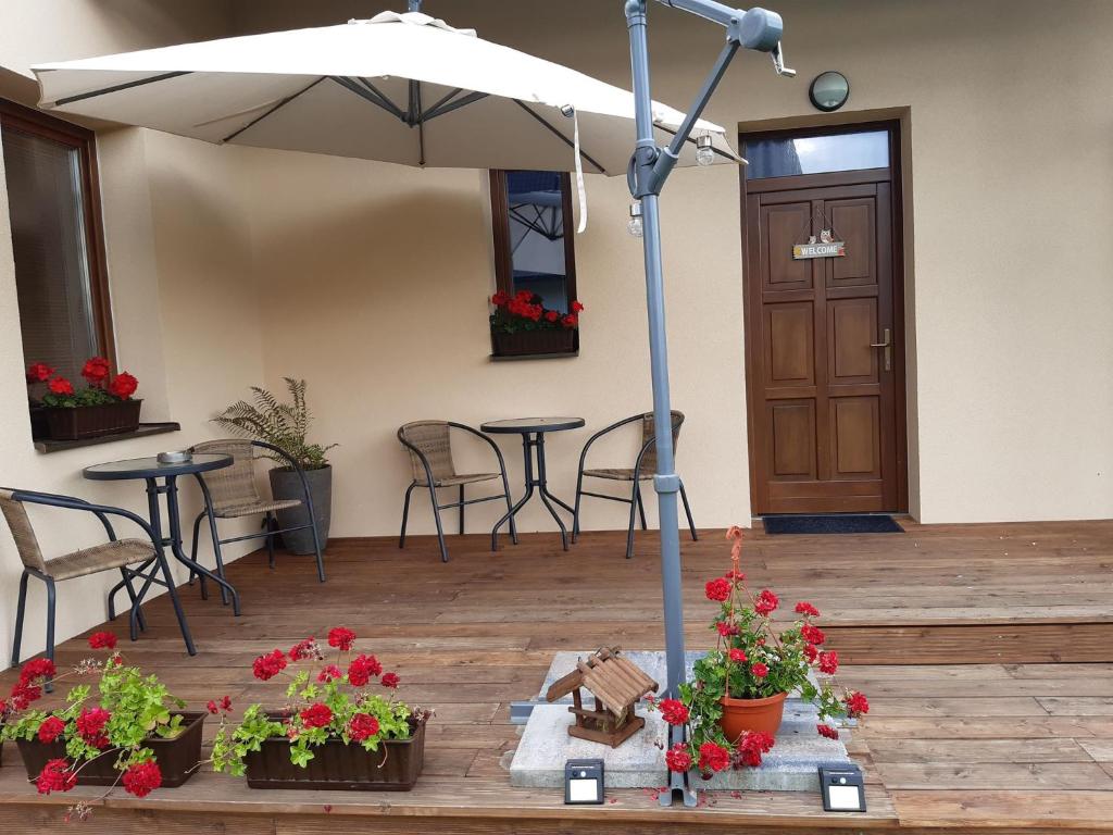 un patio con ombrellone, tavoli e sedie di Home Katka a Bešeňová