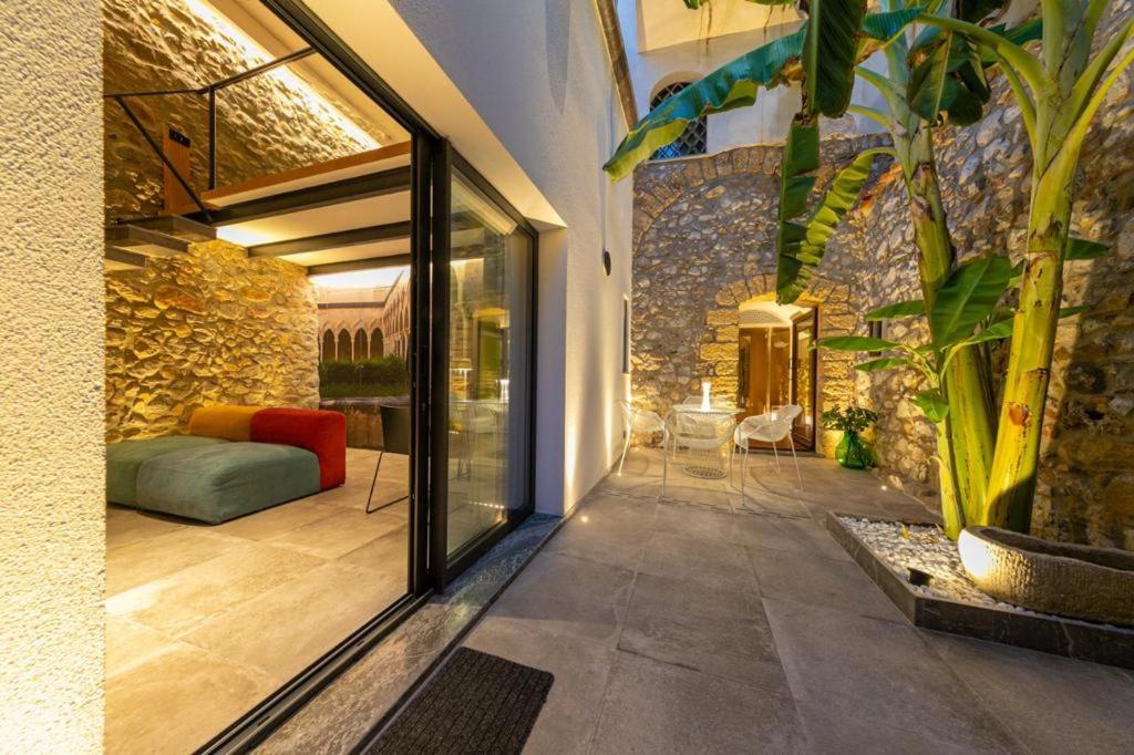 una casa con una puerta de cristal que da a un patio en MORAMUSA Charme Apartment, en Cefalú