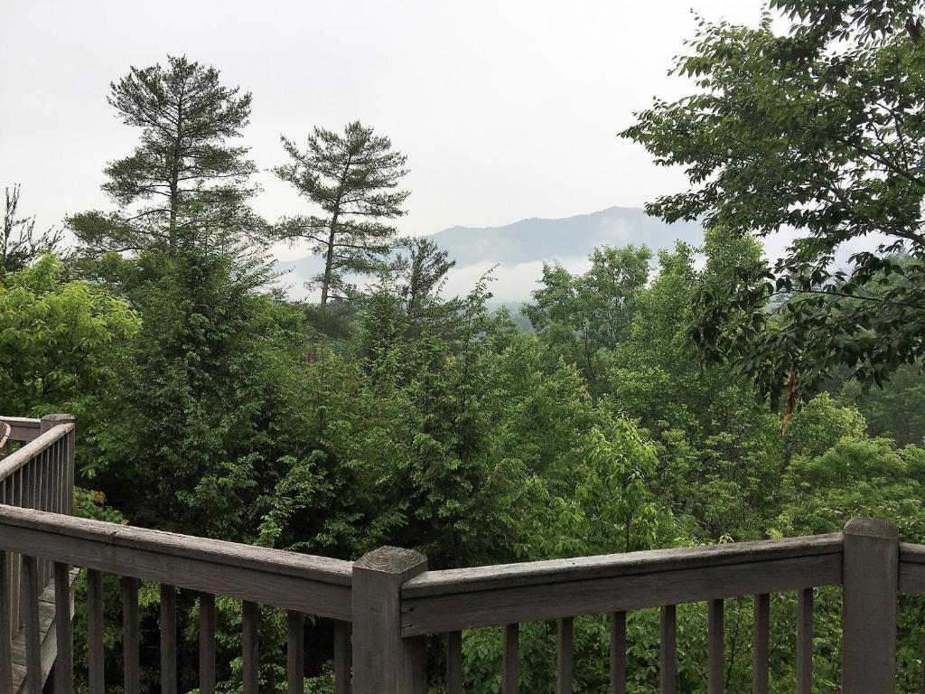 a wooden deck with a view of trees and mountains at Serendipity in Townsend