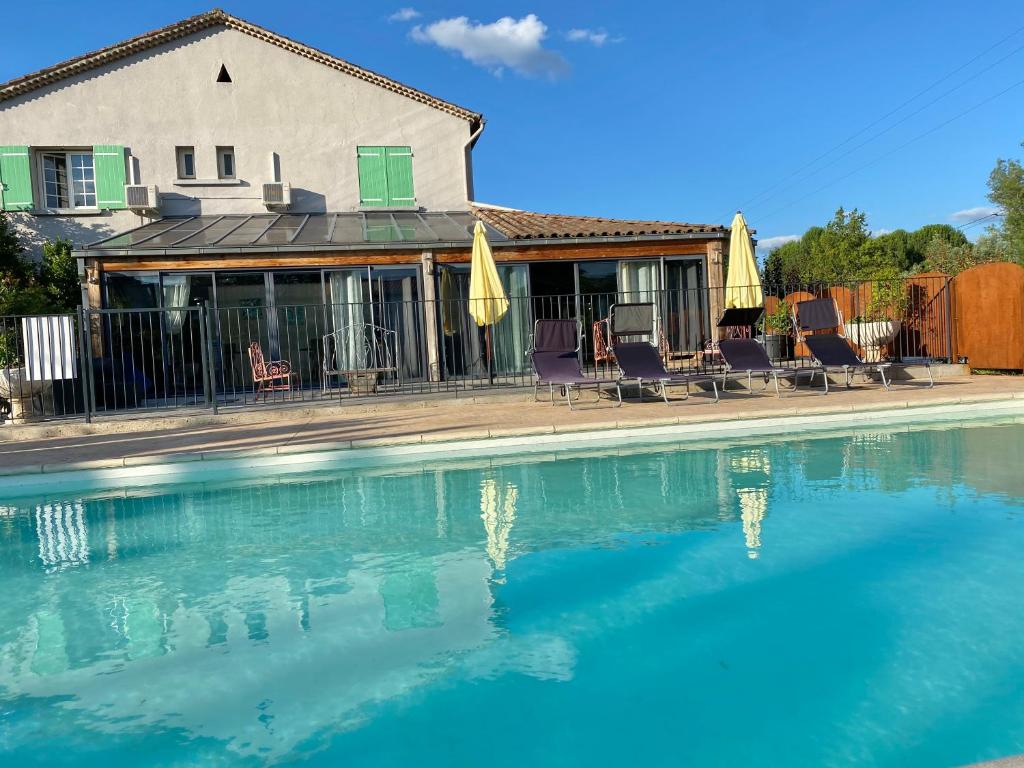 een zwembad met stoelen en een huis bij Le Plan B - Hôtel 3 étoiles - Restaurant in Ruoms