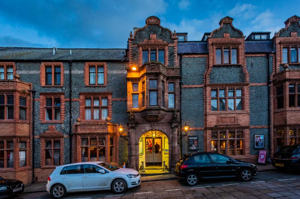 two cars parked in front of a large brick building at The Castle Hotel, Conwy, North Wales - The Coaching Inn Group in Conwy