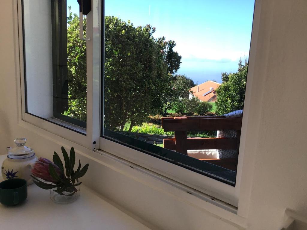 a window with a view of a balcony at Bungalows Do Amparo in Ponta do Pargo