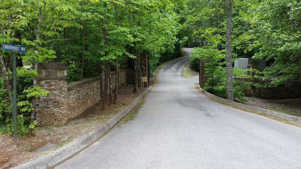 an empty road with trees and a stone wall at Pipers Place in Townsend