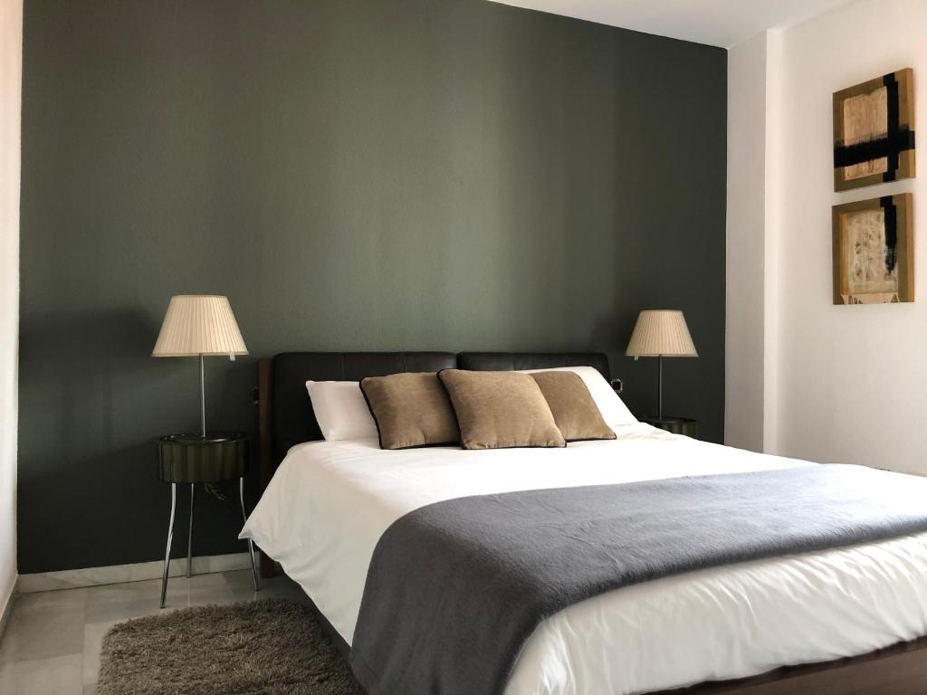 ヘレス・デ・ラ・フロンテーラにあるApartamento Los Olivos Jerezのベッドルーム1室(大型ベッド1台、ランプ2つ付)
