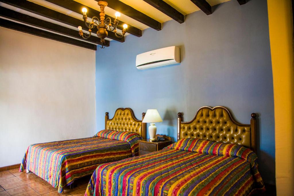 Postel nebo postele na pokoji v ubytování Hotel Cosmos Don Carlos