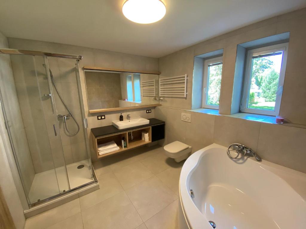 a bathroom with a tub and a shower and a sink at Apartman Relax in Zvolen