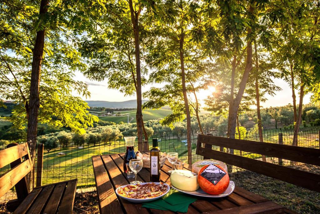 een picknicktafel met eten en wijn en uitzicht bij Agriturismo Il Sambuco in Siena