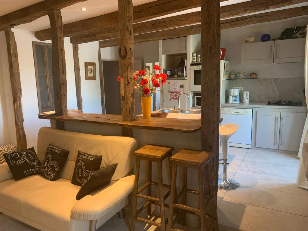 a living room with a couch and a kitchen at La Maison De Chloe in Senouillac