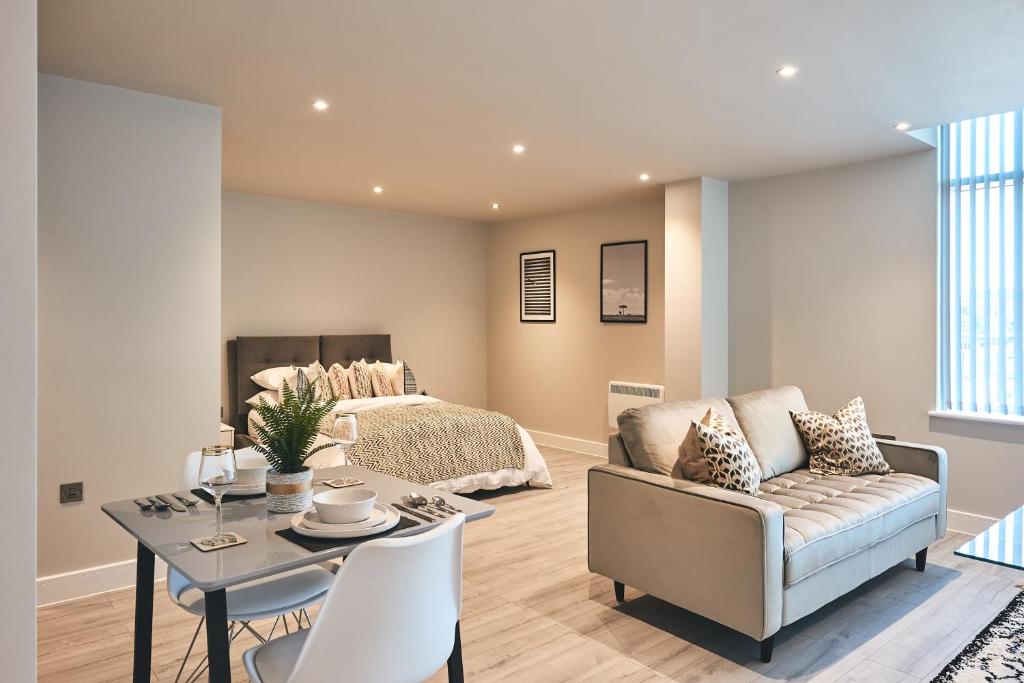 a living room with a bed and a couch and a table at Seven Living Bracknell - Serviced Apartments in City Centre - Free Parking in Bracknell