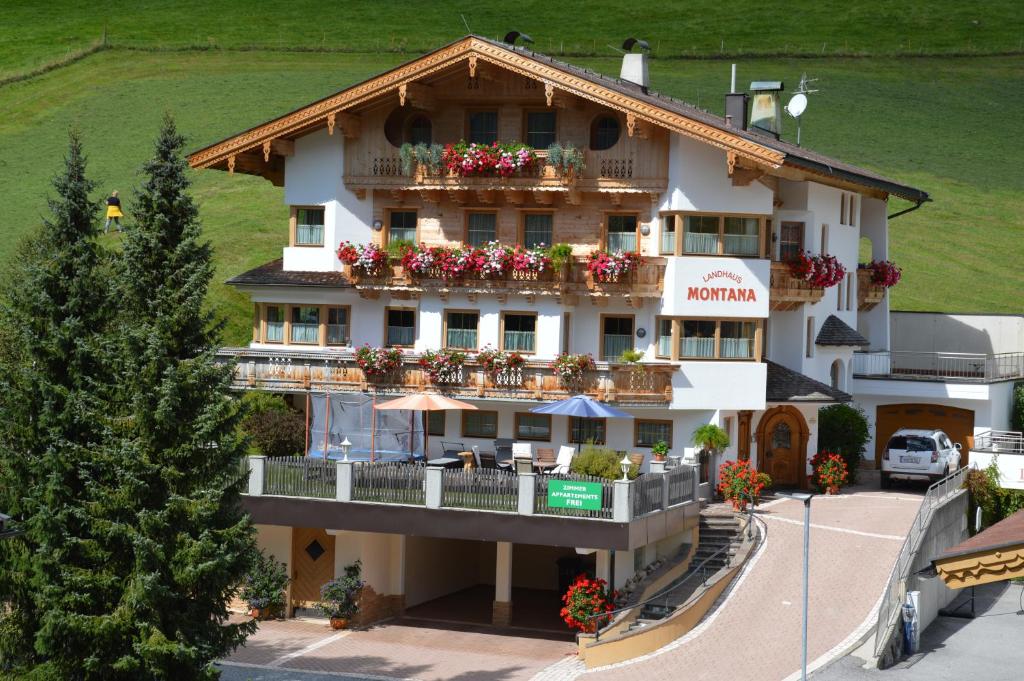 duży budynek z balkonami i kwiatami na nim w obiekcie Landhaus Montana w mieście Gerlos