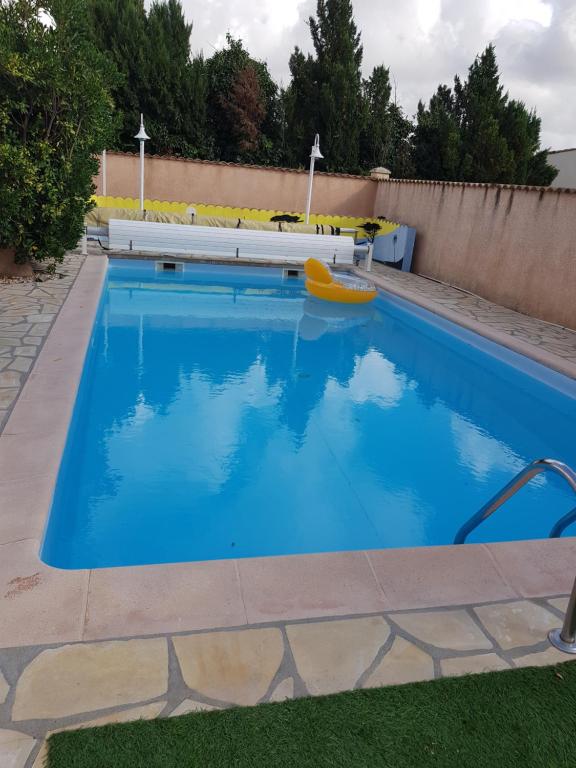 uma grande piscina com uma jangada amarela no meio em Le CLOS D'AMANDINE em Sallèles-dʼAude