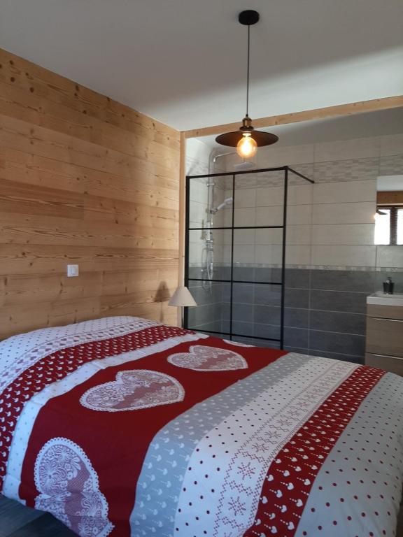 a bedroom with a bed with a red and white blanket at La Maison Trésallet in La Plagne Tarentaise