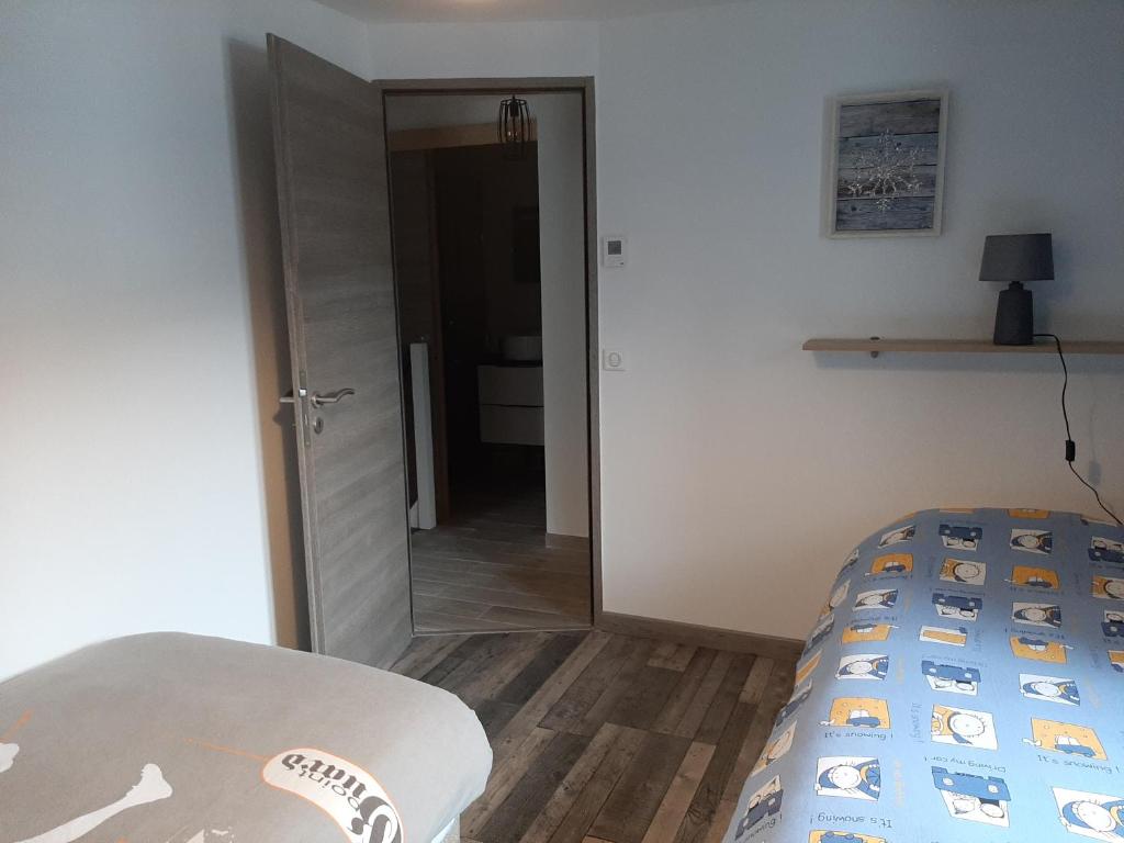 a bedroom with a bed and a door with a mirror at La Maison Trésallet in La Plagne Tarentaise