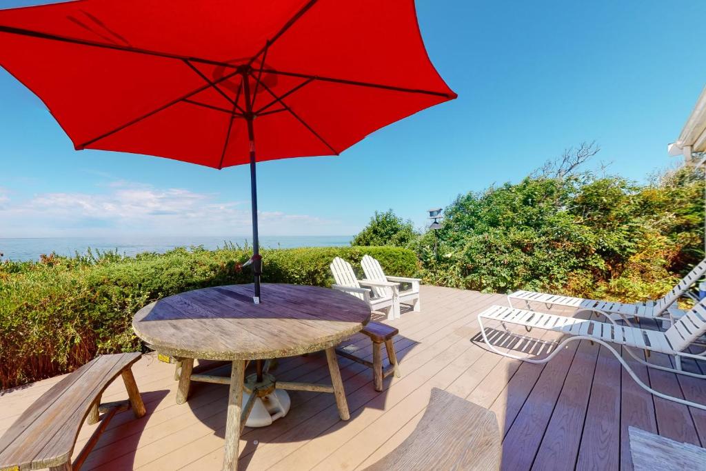 a table and chairs with a red umbrella on a deck at 2 Bed 1 Bath Vacation home in Eastham in Eastham