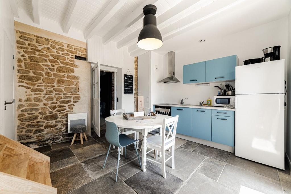 uma cozinha com uma mesa e um frigorífico branco em Les Villas de Locmiquel BORD DE MER em Baden