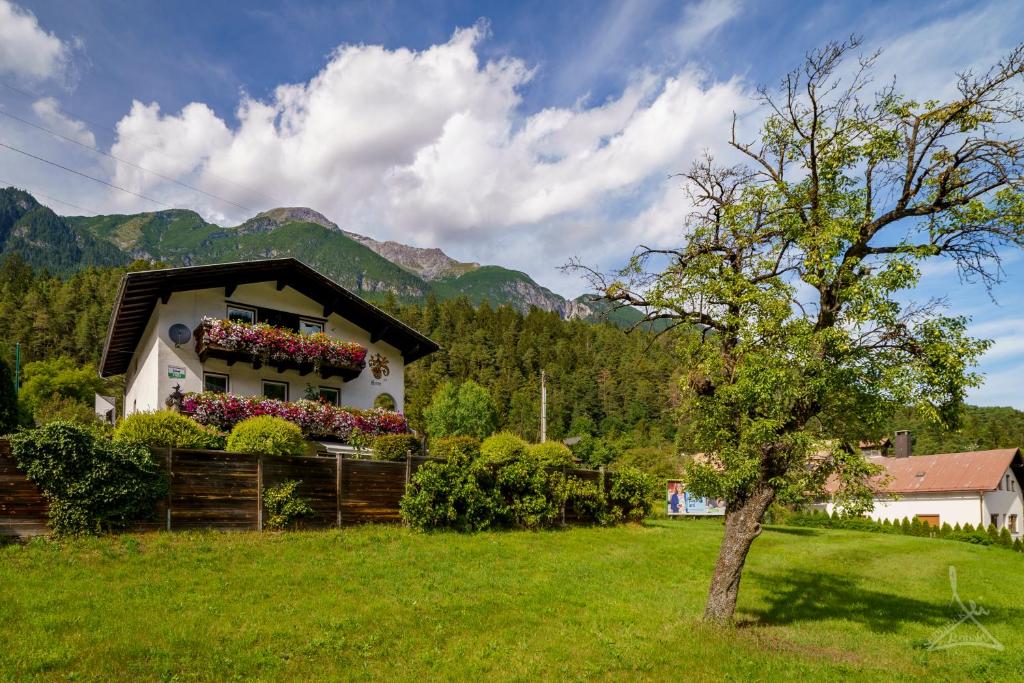 una casa con cajas de flores a un lado. en Ferienwohnung Kobler, en Landeck