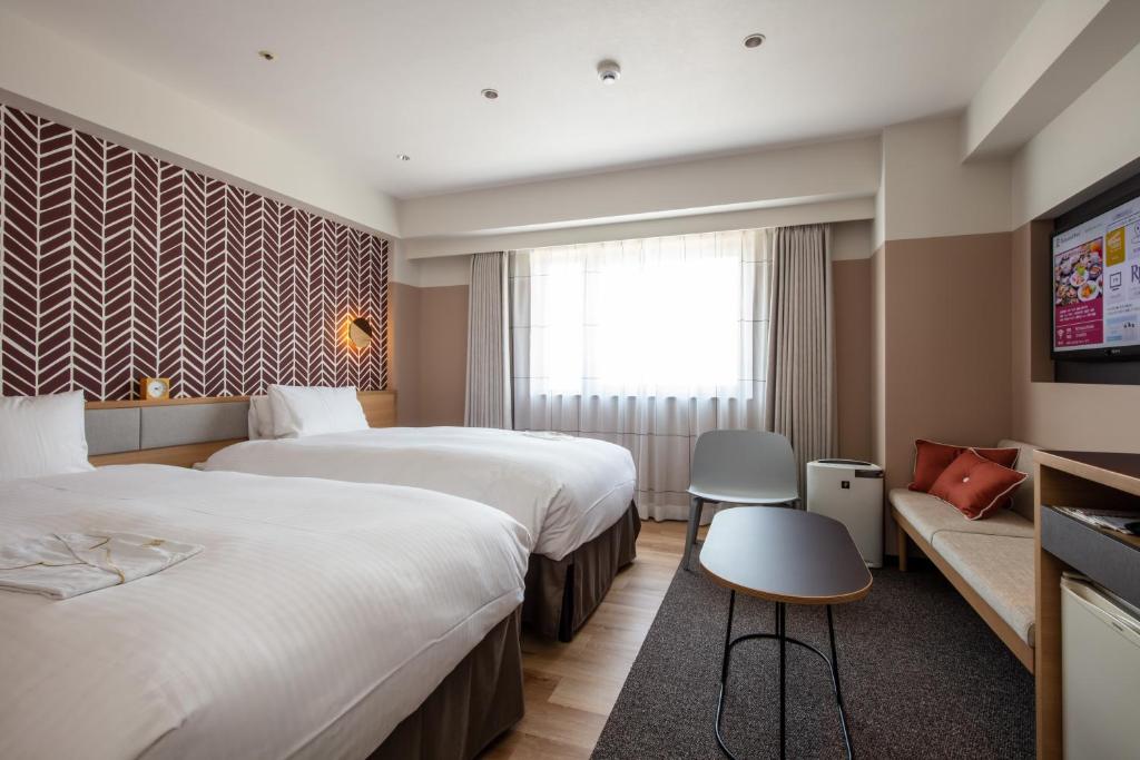 松本市にあるリッチモンドホテル松本のベッド2台とテレビが備わるホテルルームです。