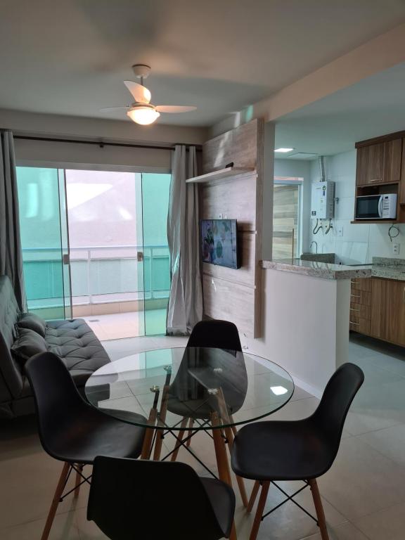 a living room with a glass table and chairs at PORTO AZUL - Praia do Forte - Apart in Cabo Frio