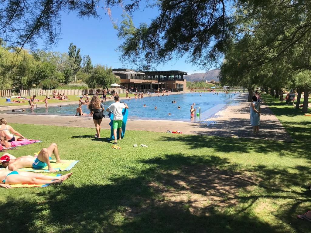 un grupo de personas yaciendo en la hierba en una piscina en Rubina Resort, en Empuriabrava