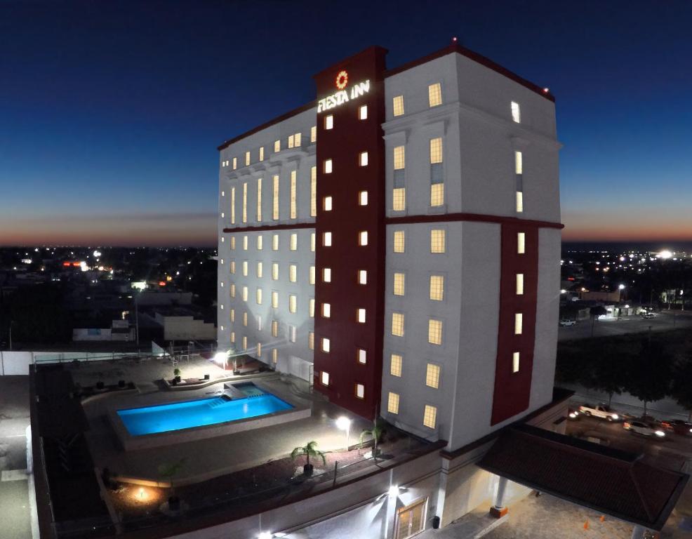 un hôtel avec une piscine en face d'un bâtiment dans l'établissement Fiesta Inn Ciudad Obregon, à Ciudad Obregón