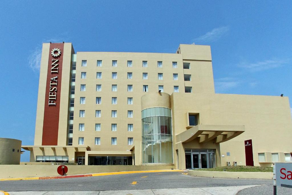 un bâtiment d'hôtel avec un panneau sur son côté dans l'établissement Fiesta Inn Coatzacoalcos, à Coatzacoalcos