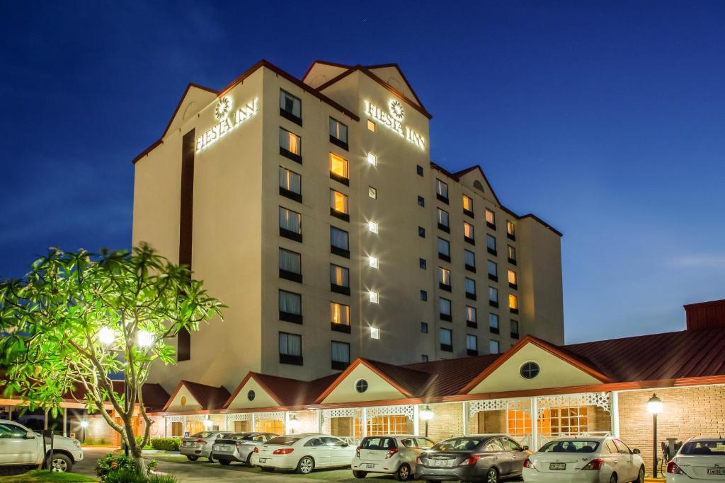 un hôtel avec des voitures garées dans un parking dans l'établissement Fiesta Inn Tampico, à Tampico