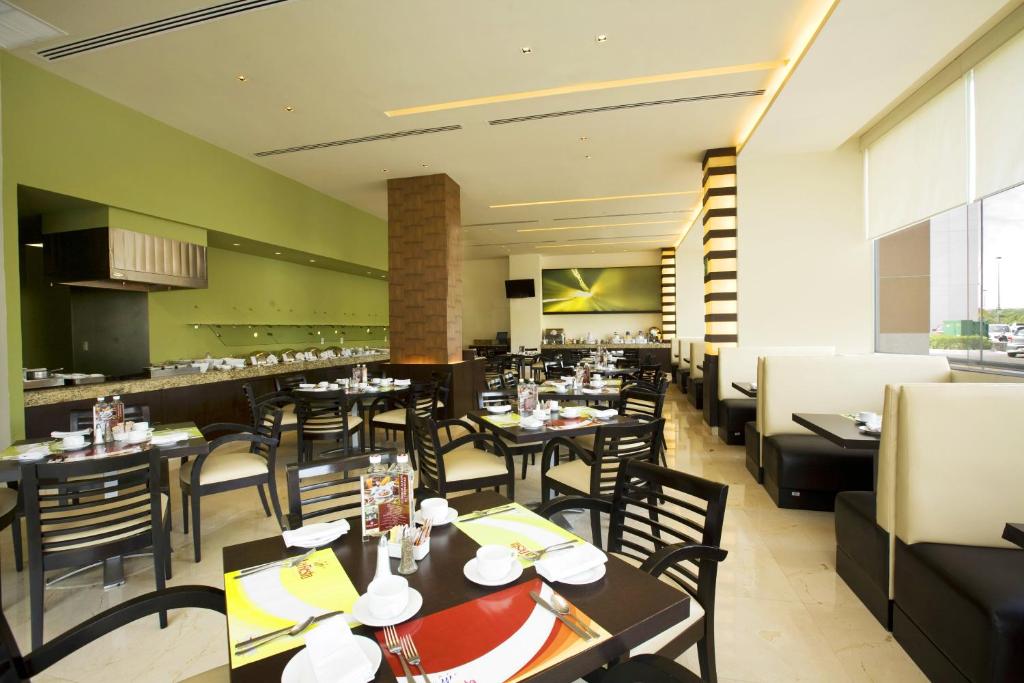 una sala da pranzo con tavoli e sedie in un ristorante di Fiesta Inn Tepic a Tepic