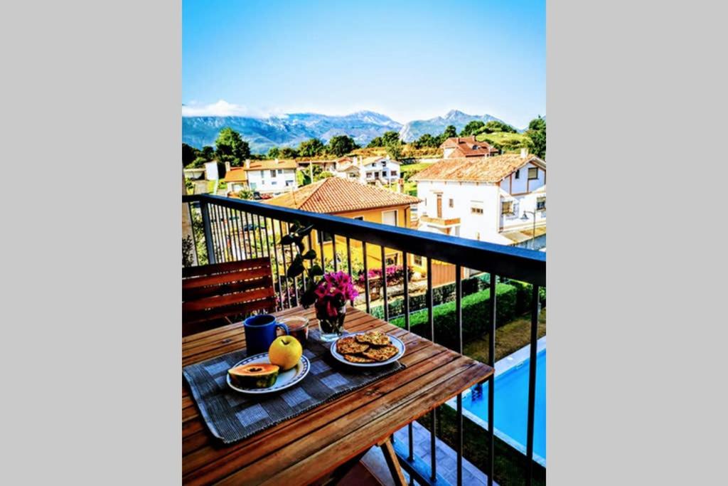 uma mesa com comida em cima de uma varanda em Diañu, apartamento con Piscina en Llanes em Llanes