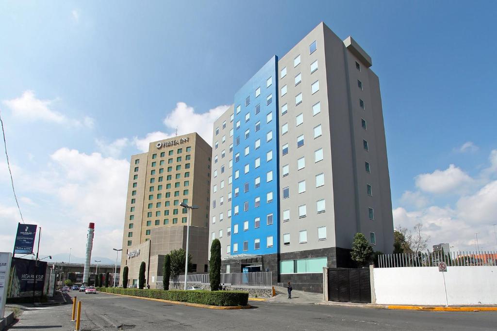 a tall building on a street in a city at One Periferico Sur in Mexico City