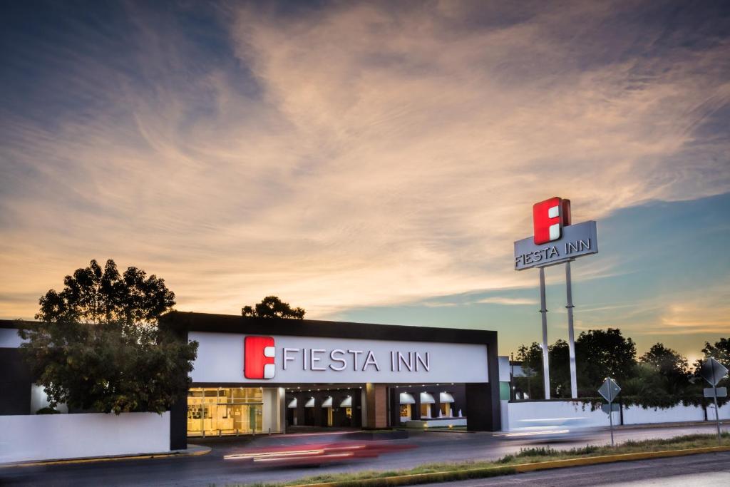 una señal de una posada de fiesta frente a una tienda en Fiesta Inn San Luis Potosi Glorieta Juarez, en San Luis Potosí