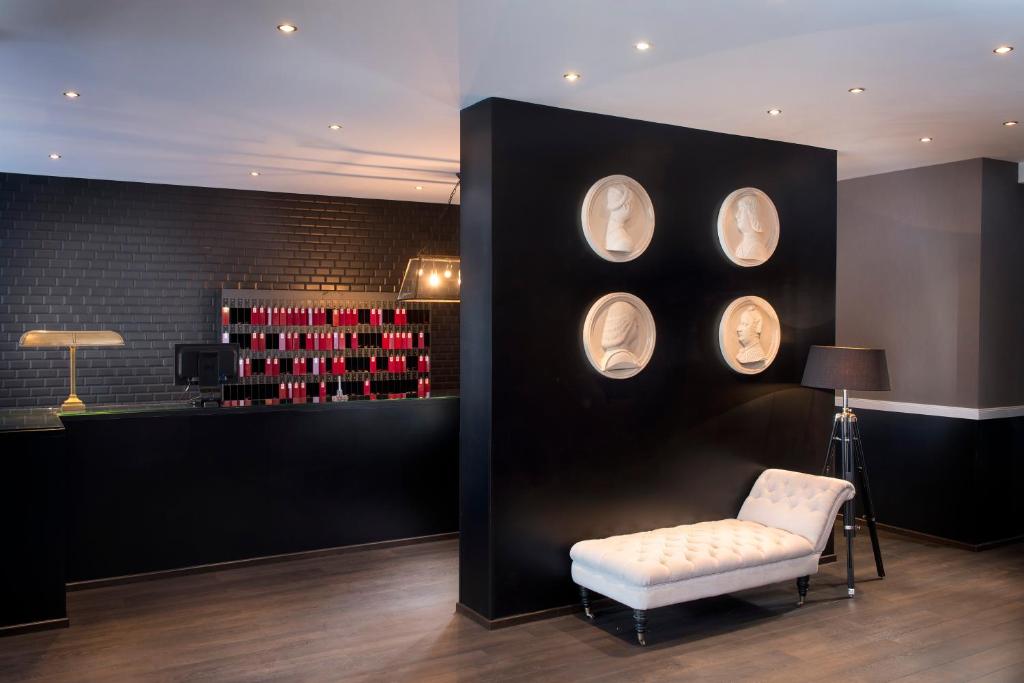Habitación con silla y pared con botellas de vino en Hotel Excelsior Ludwigshafen, en Ludwigshafen am Rhein