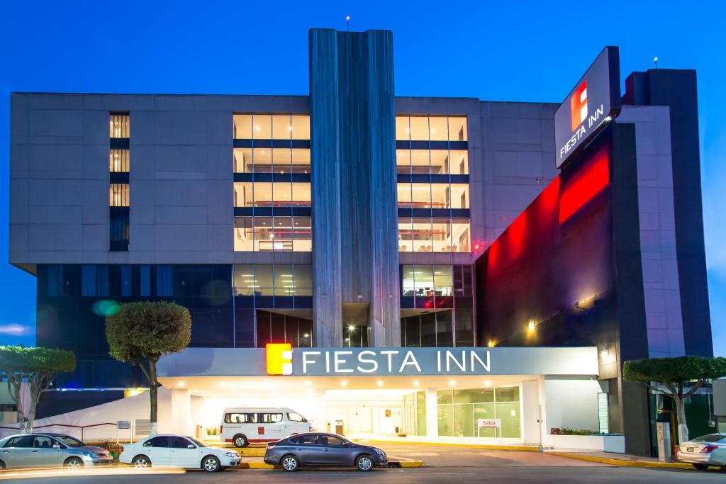 una estación de bomberos con coches estacionados frente a un edificio en Fiesta Inn Tlalnepantla, en Ciudad de México