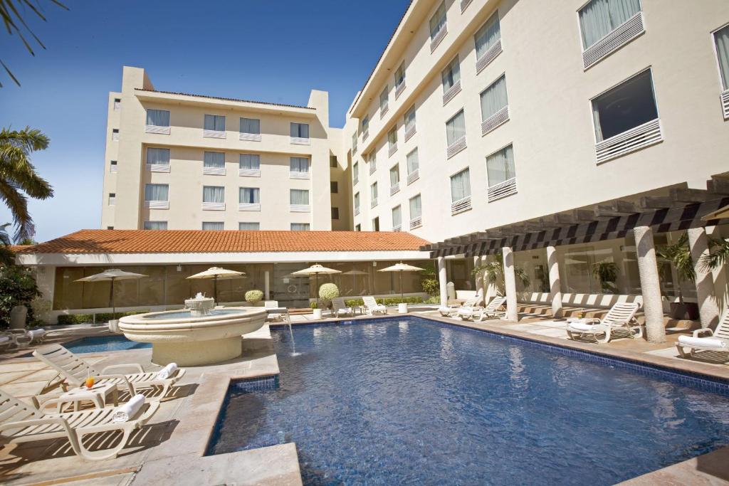 a swimming pool in front of a building at Fiesta Inn Ciudad del Carmen in Ciudad del Carmen