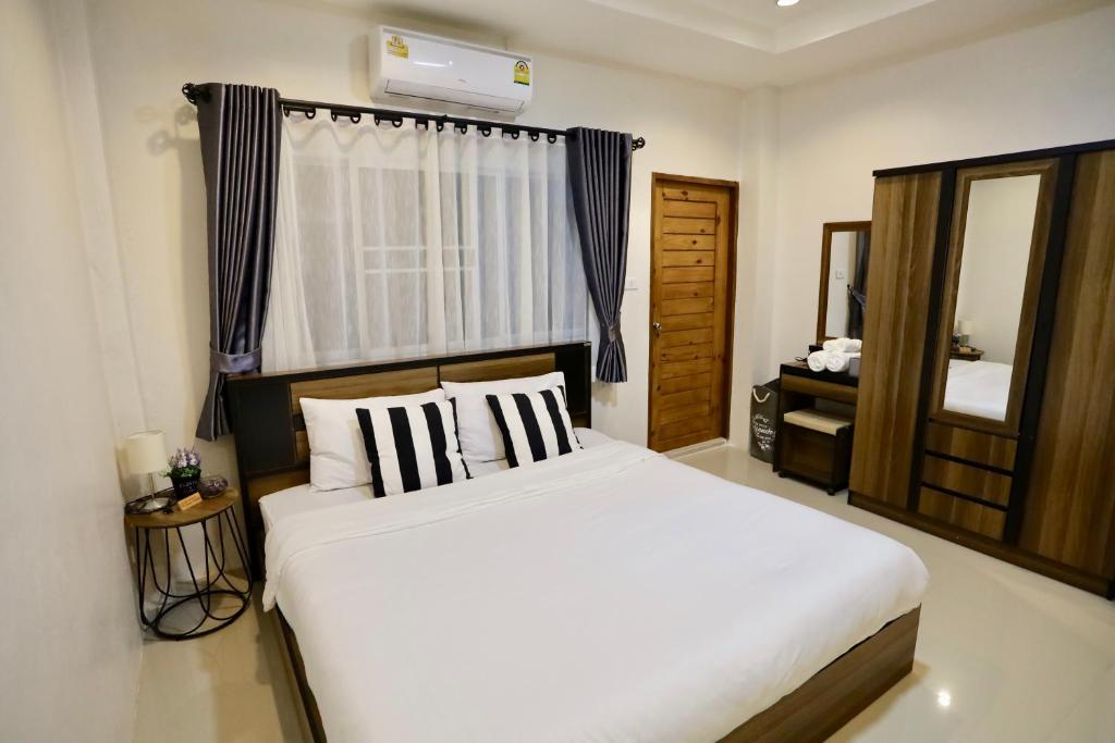 a bedroom with a large white bed and a mirror at 20° North Hotel Mae Sai in Mae Sai