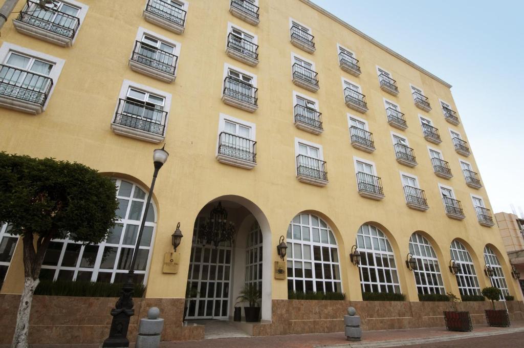 un edificio amarillo con ventanas y balcones. en Fiesta Inn Toluca Centro, en Toluca