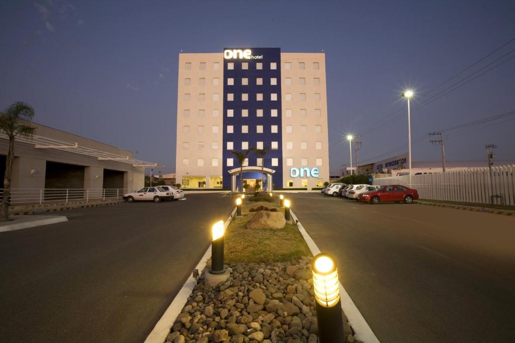 un bâtiment avec des lumières au milieu d'une rue dans l'établissement One Aguascalientes Sur, à Aguascalientes